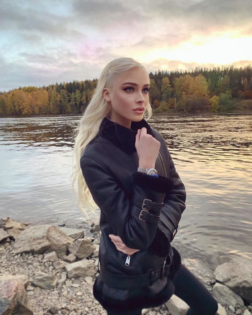 Алена Шишкова позирует на фоне реки и осеннего леса